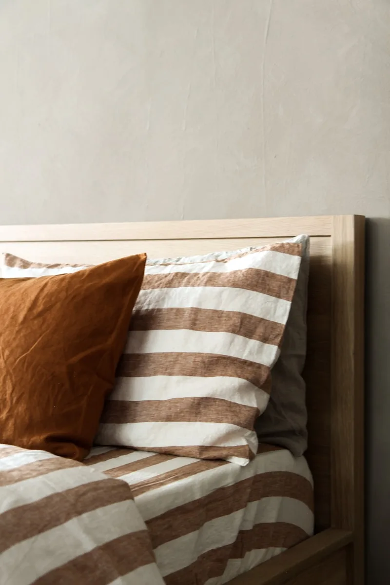 Made bed with fresh striped linen
