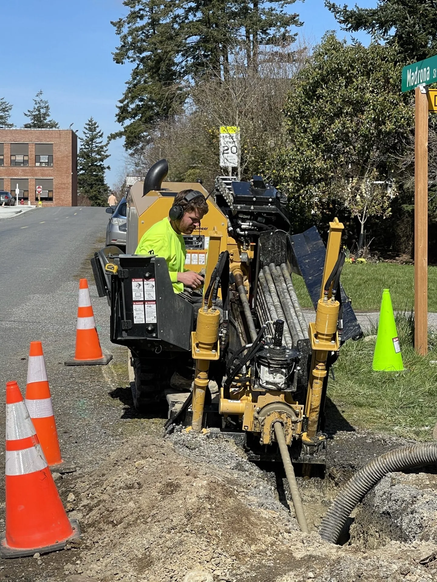 Crew member running a directional drill rig at a street corner