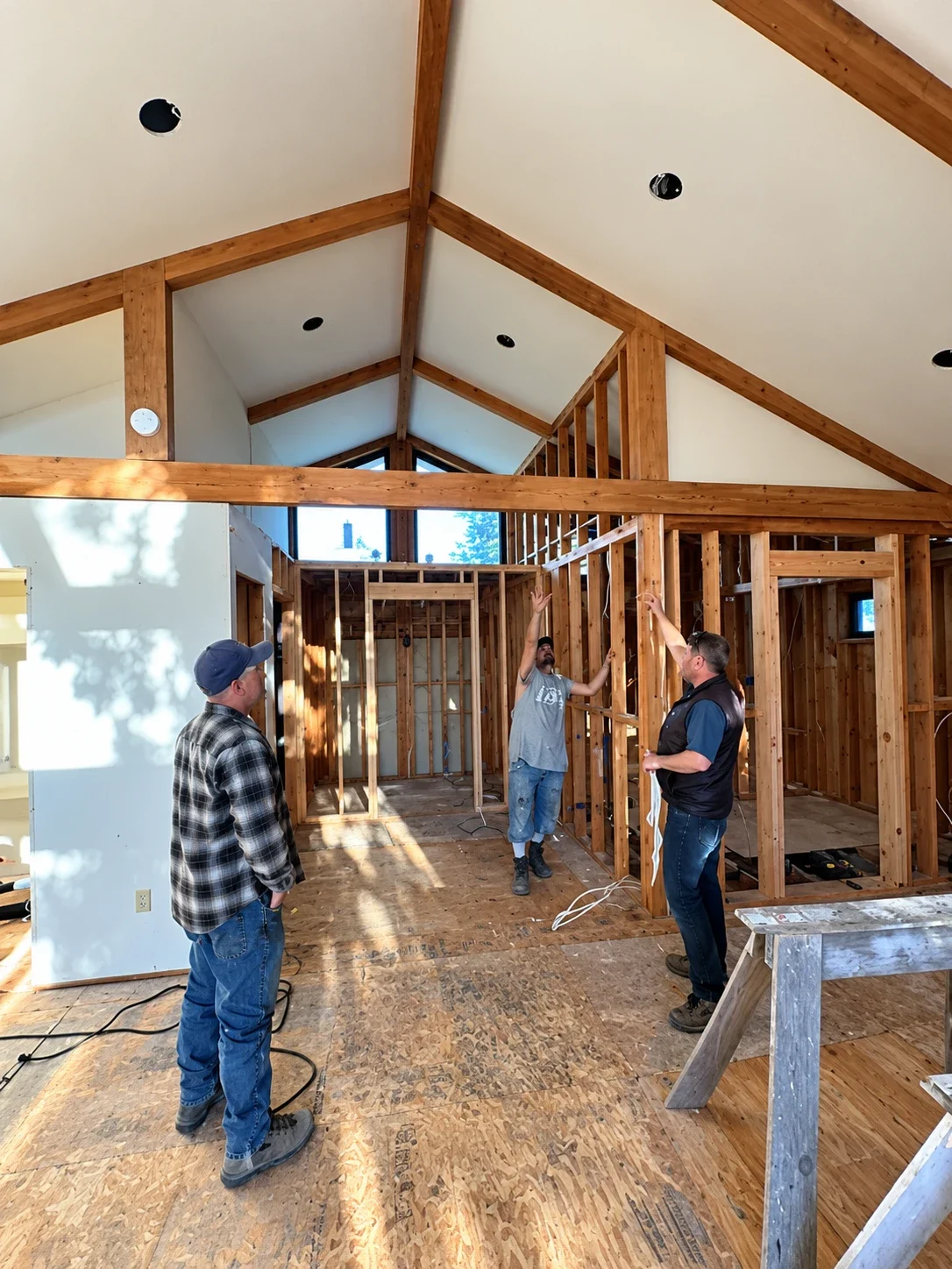 Crew planning a renovation under a vaulted, timber-framed ceiling
