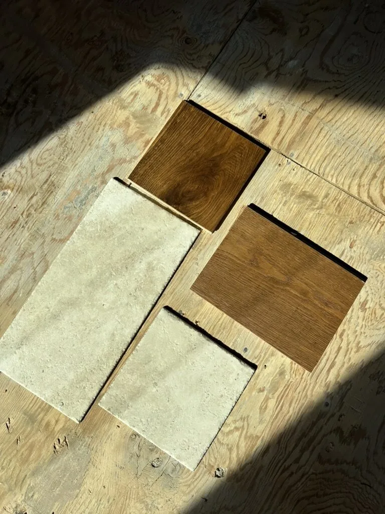 Oak flooring and natural stone tile samples laid out in the sun