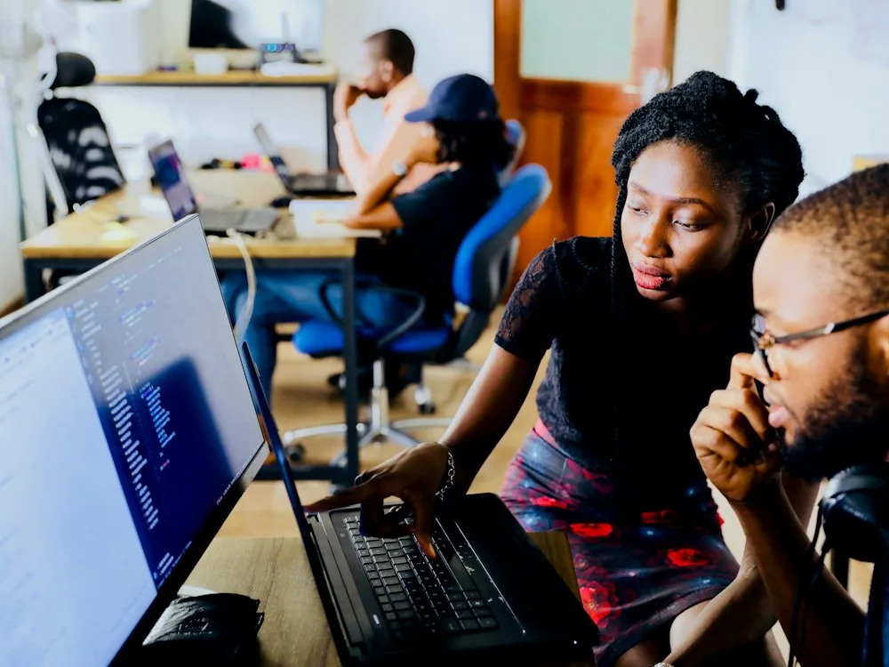 Two colleagues reviewing network configuration on screen