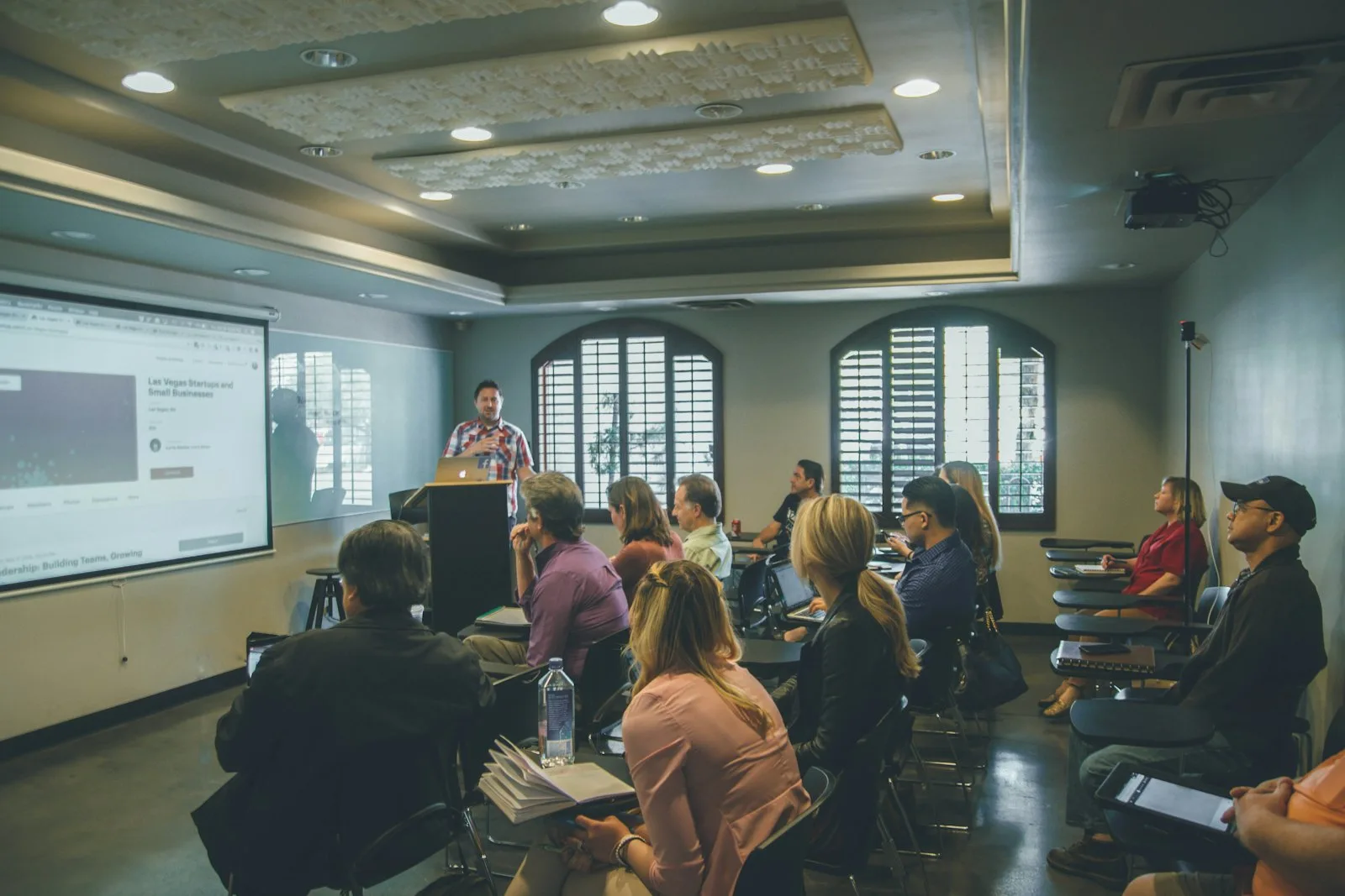Volunteers sitting together in a training session while a facilitator presents at the front of the room