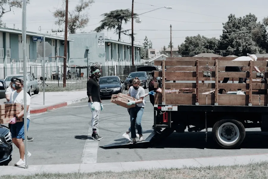 Volunteers carrying boxes of supplies from a truck at an outreach distribution