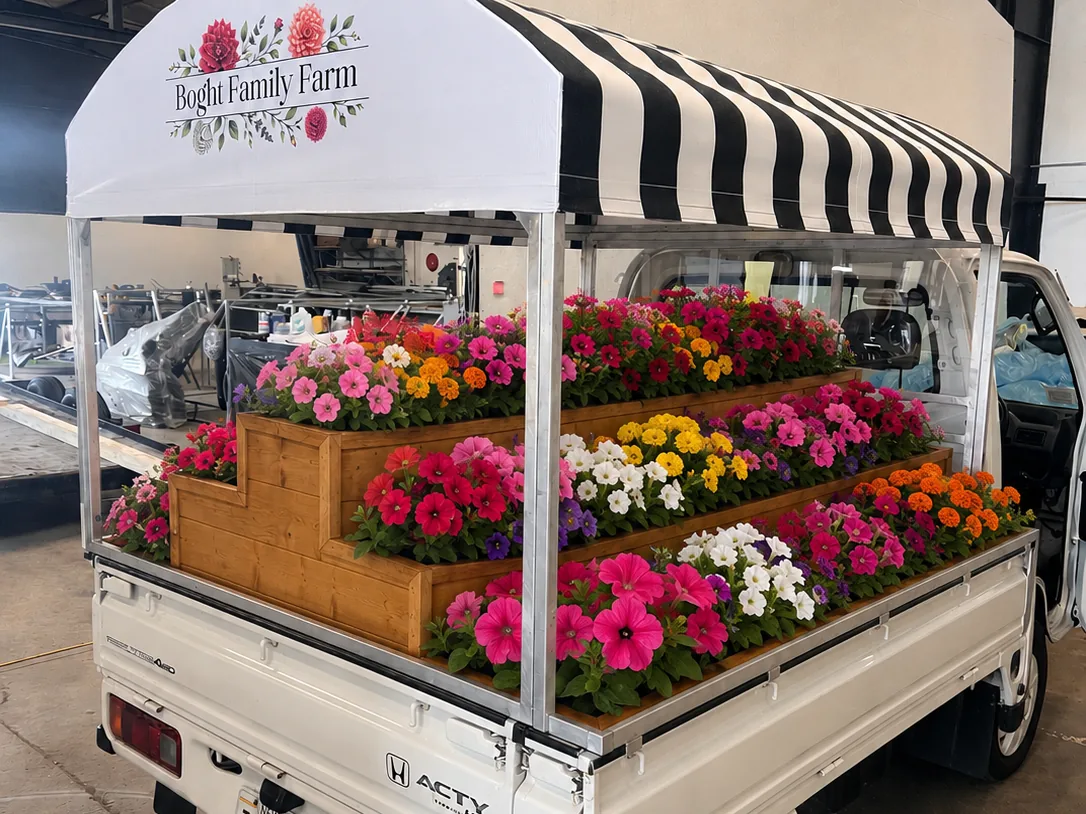 The Boght Family Farm flower truck loaded with tiered trays of pink, white and orange blooms
