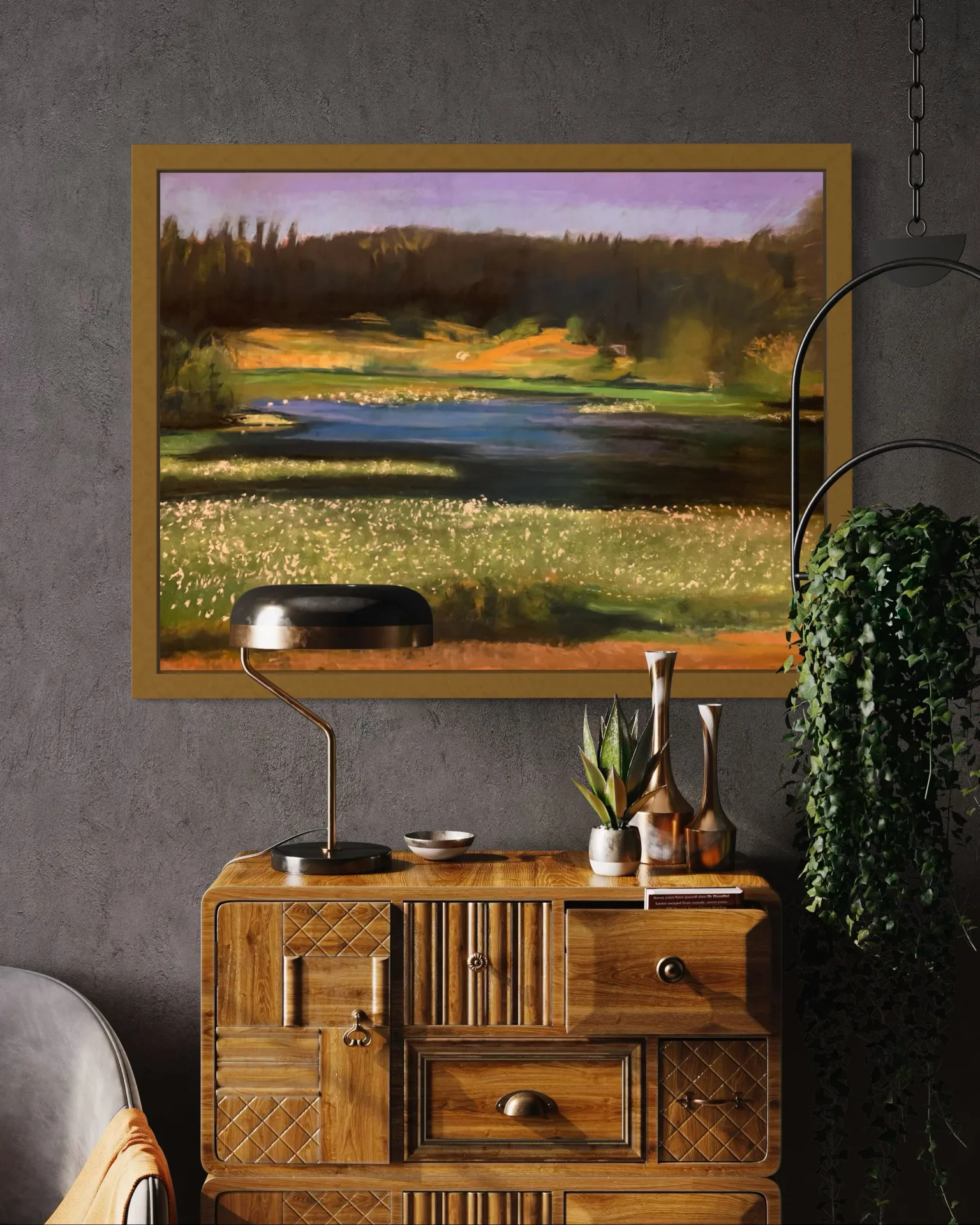 The framed pond pastel hung above a wooden sideboard in a plaster-grey room, beside a trailing houseplant
