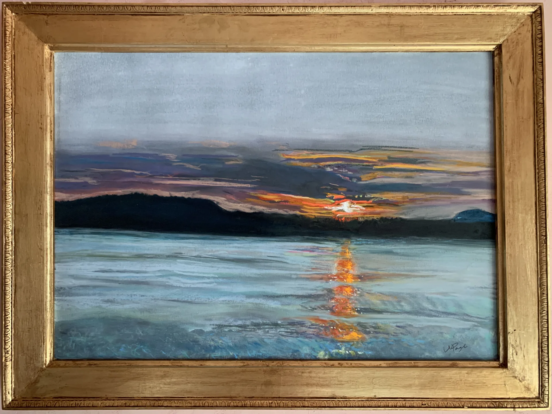 Framed pastel of a sunset glowing low behind a dark island, repeated as a narrow bright seam on the water below