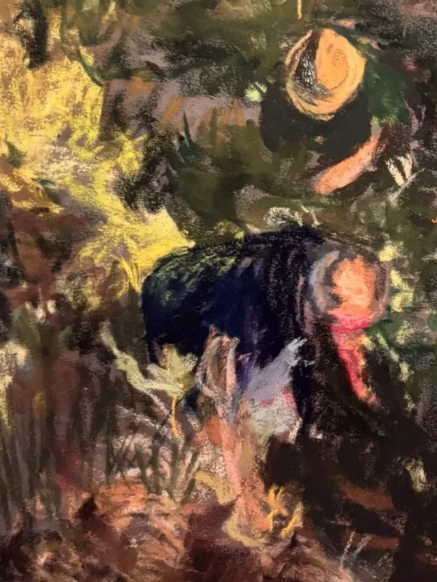 Close-up of the two figures, a straw hat and a red collar picked out of the dark