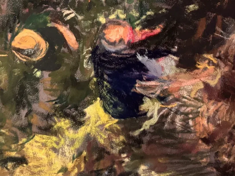 Close-up of the two figures, a straw hat and a red collar picked out of the dark