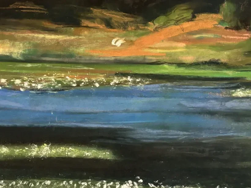 Close-up of the far bank: orange field light lying flat above the blue of the water