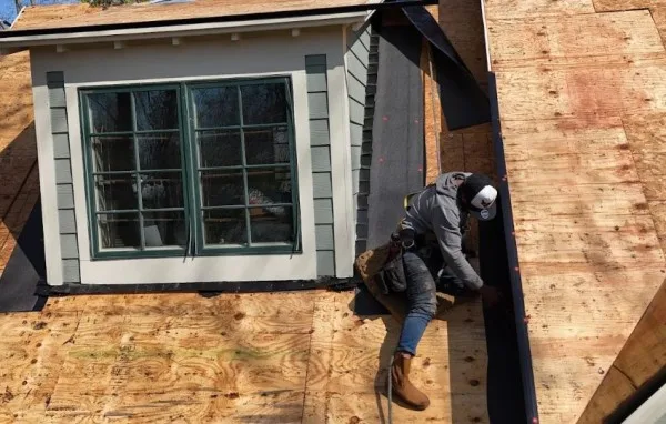 Roofer installing new decking around a dormer