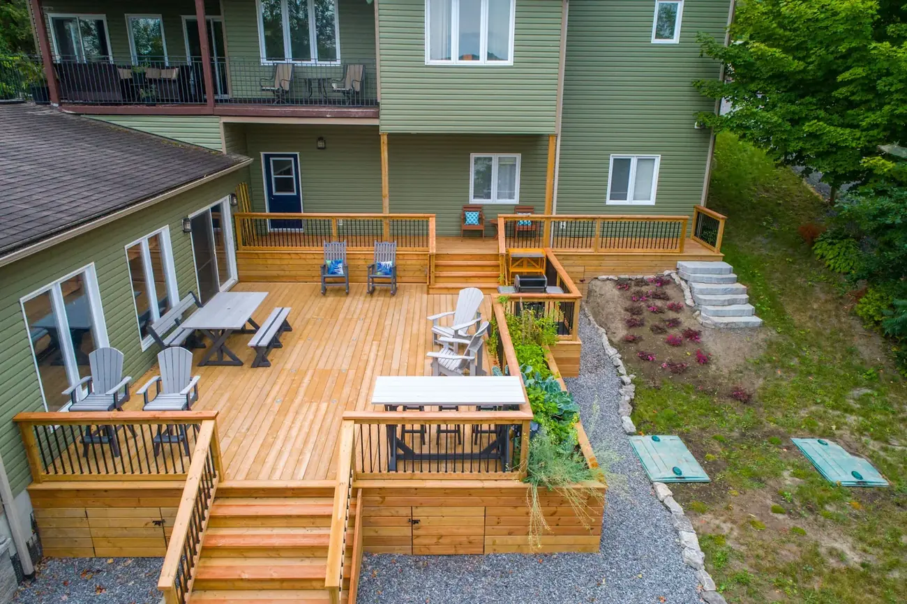 A newly built deck with stairs and railing at the back of a house