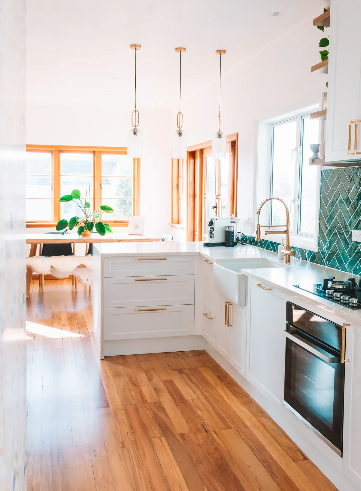 A remodeled kitchen with white cabinetry, tile, and wood floors