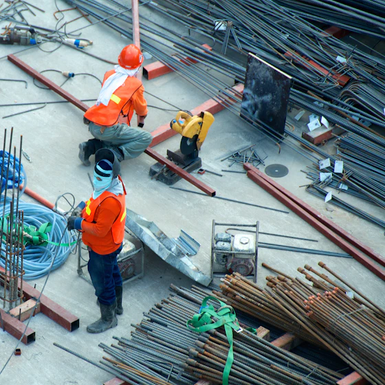 Site workers laying reinforcing bar on a construction deck