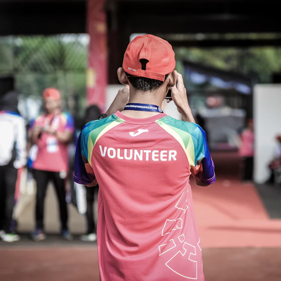 A volunteer in a branded shirt at a community event