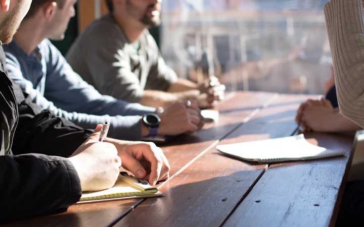 A team reviewing notes together around a table during a technology assessment