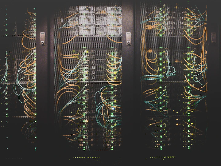 Racks of servers and fibre patching in a darkened data centre