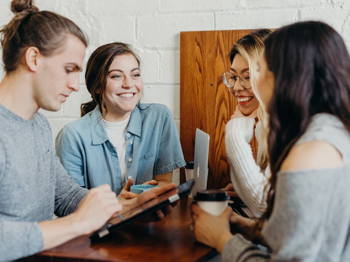 Four colleagues talking together around a cafe table