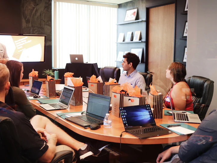 A team around a boardroom table with laptops during a strategy session