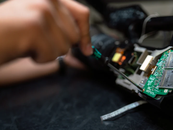 A technician repairing the internals of a device by hand