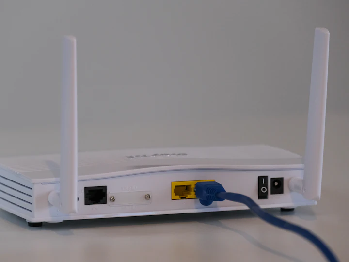 A wireless router with an ethernet cable plugged into its uplink port