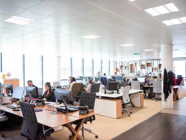 A busy open-plan office with rows of staffed desks