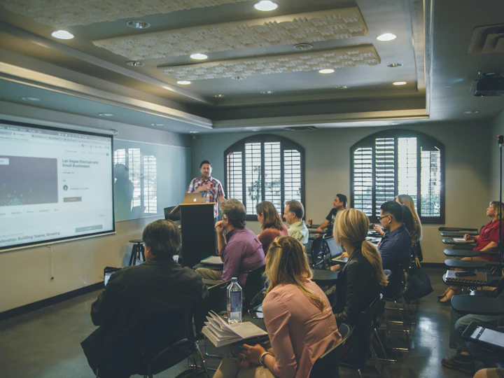 A trainer presenting to a seated group in a meeting room