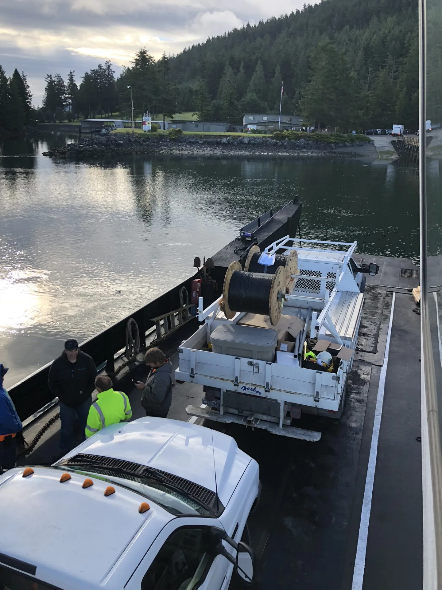 Crew and a truck loaded with cable reels crossing on an island ferry