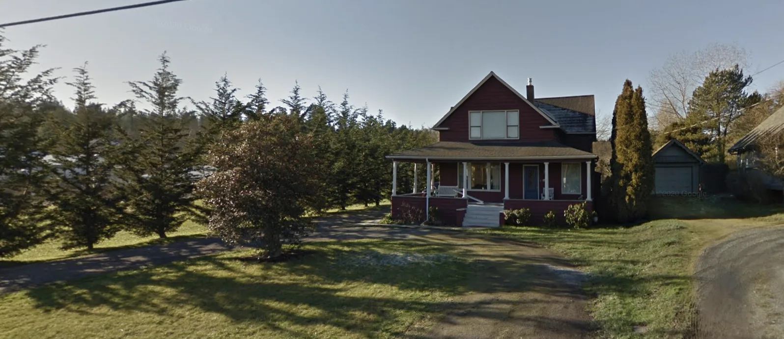 The red 1880s homestead with its wraparound porch, set among evergreens on San Juan Island.