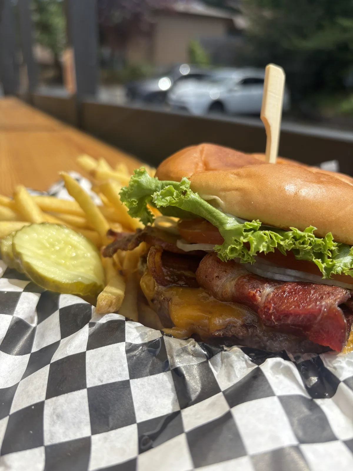 Bacon cheeseburger with fries and a pickle at The Lower Tavern