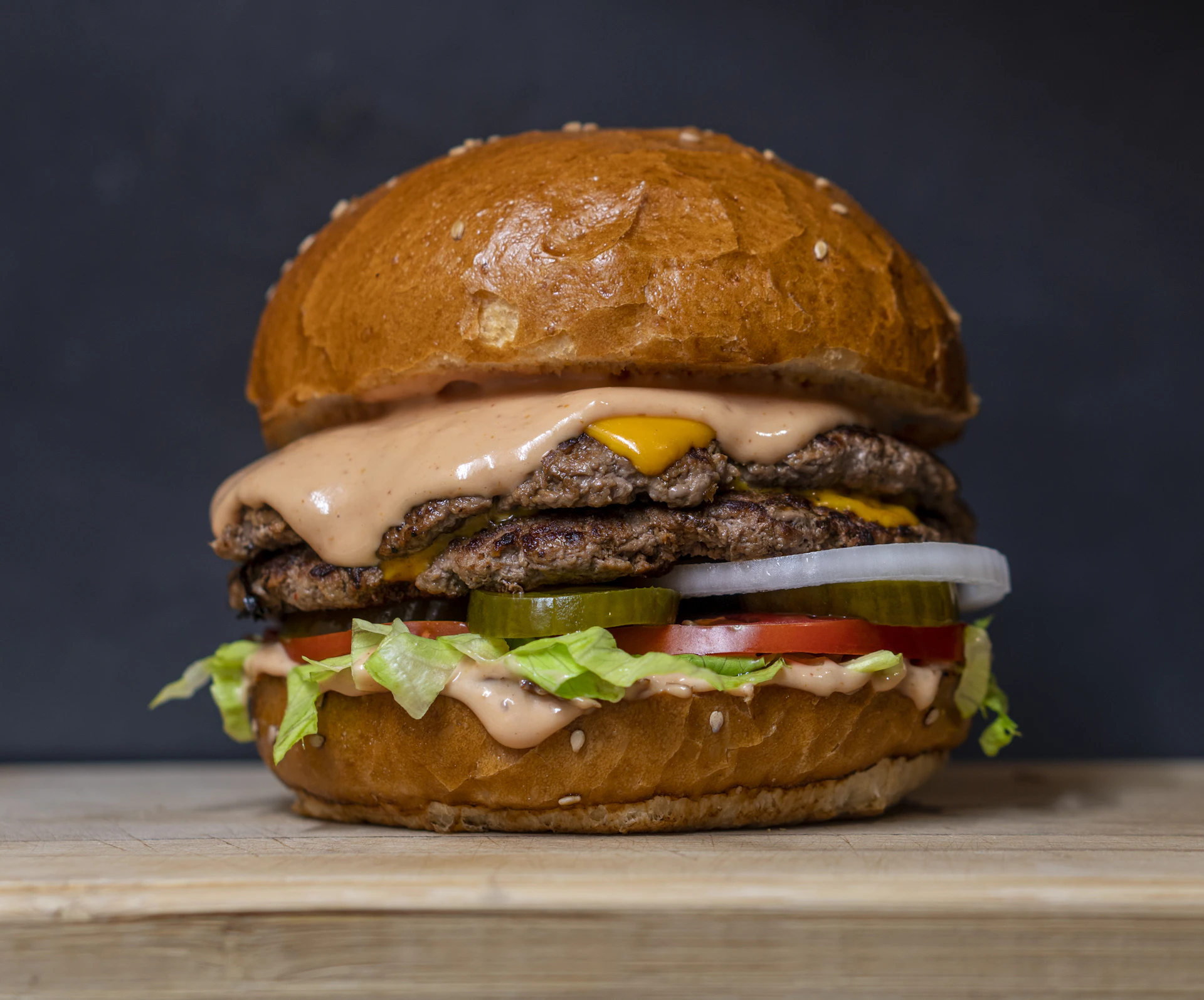 Stacked smash burger with fries and a cold beer