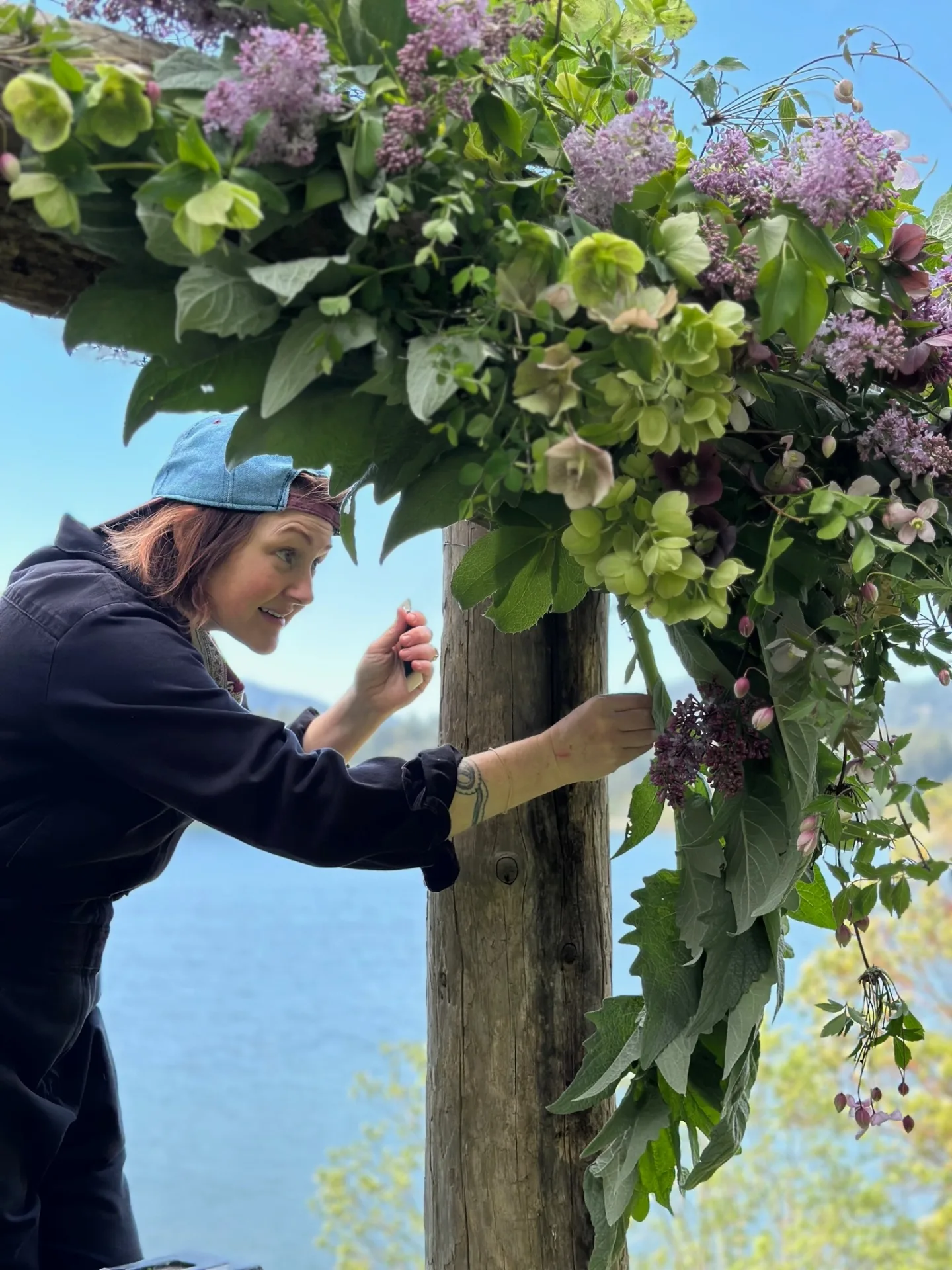 Whitney Page creating floral arch installation with lilac blooms
