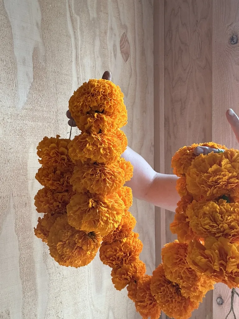 A handmade marigold garland from the Marigold Garland Workshop at Tekla Farms