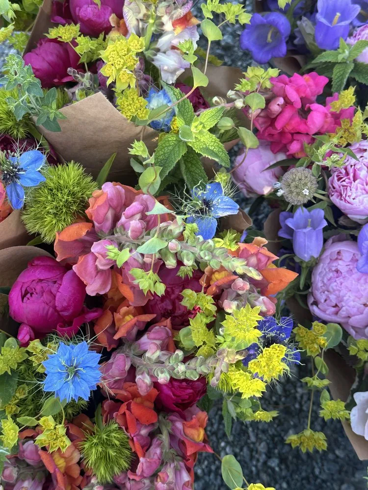 Overhead view of wrapped bouquets of peonies, snapdragons and nigella