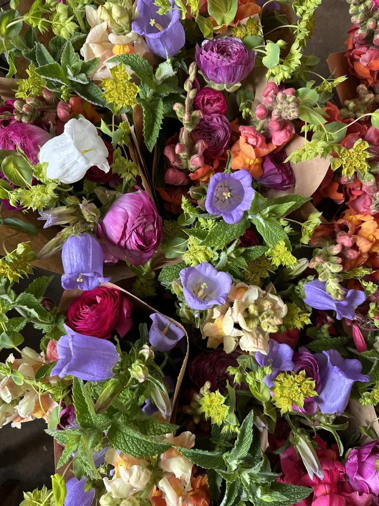 Wrapped market bouquets of ranunculus, snapdragons and campanula