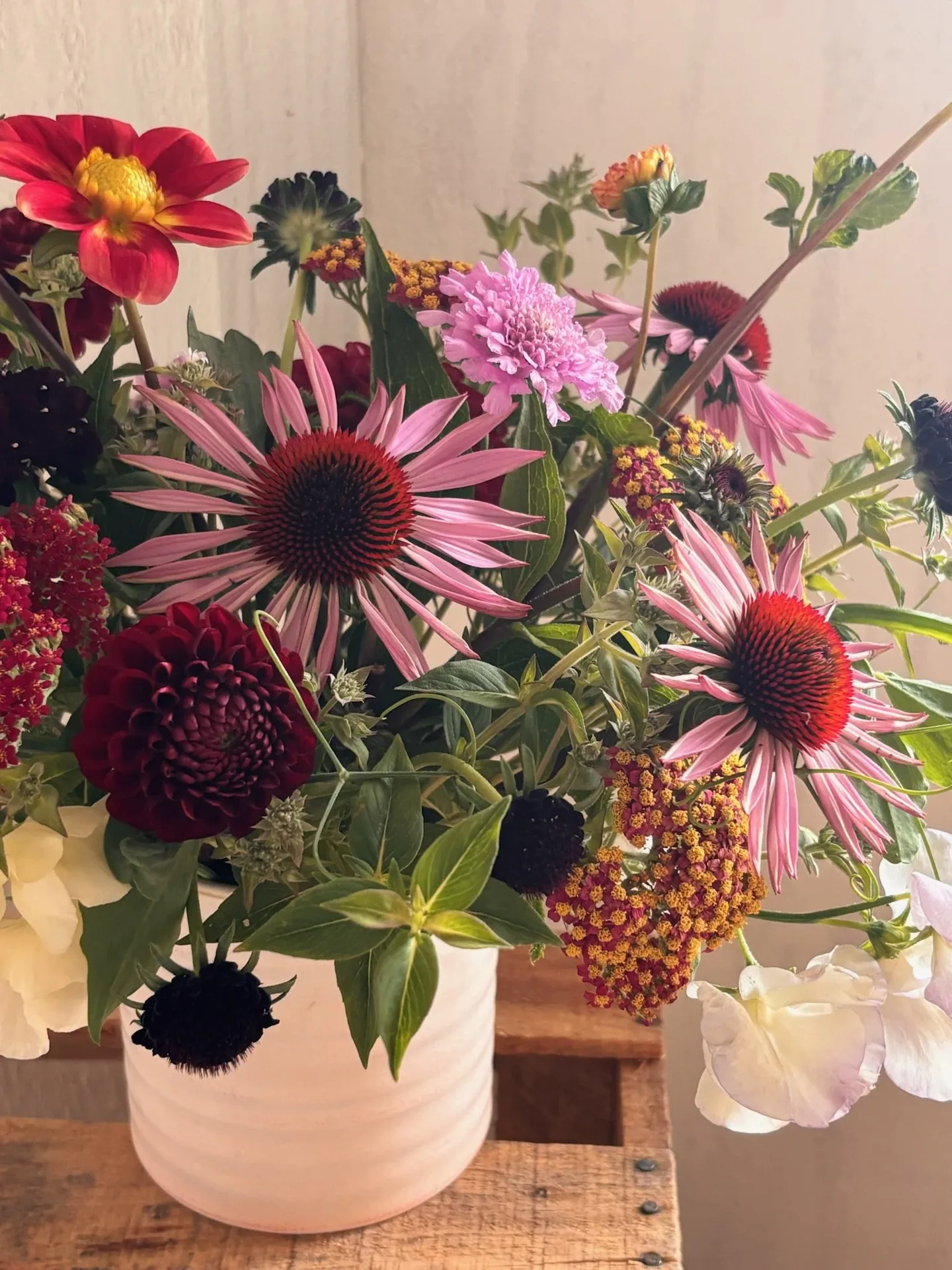 A farm-florist vase arrangement of dahlias, scabiosa and foliage