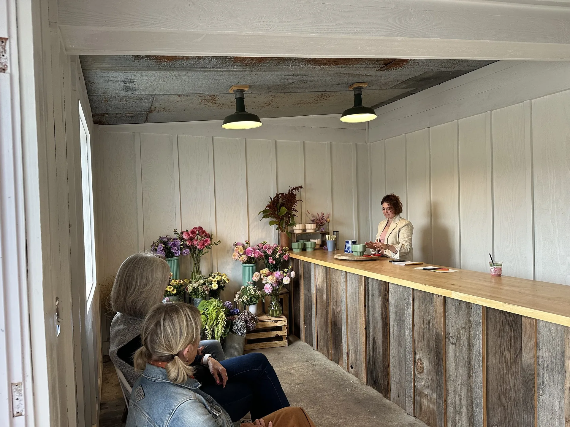 Workshop guests arranging flowers in a bright timber-clad studio